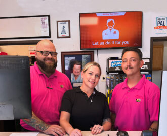 three Smoky Hill Auto Service employees behind the desk